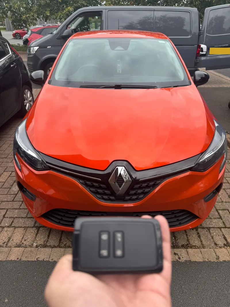Orange Renault Clio with a black Renault key card held in front of it, number plates obscured